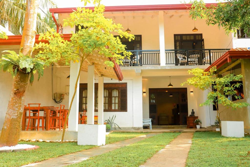a house with a porch and a balcony at AYUBELLO hostel & suites in Ahungalla