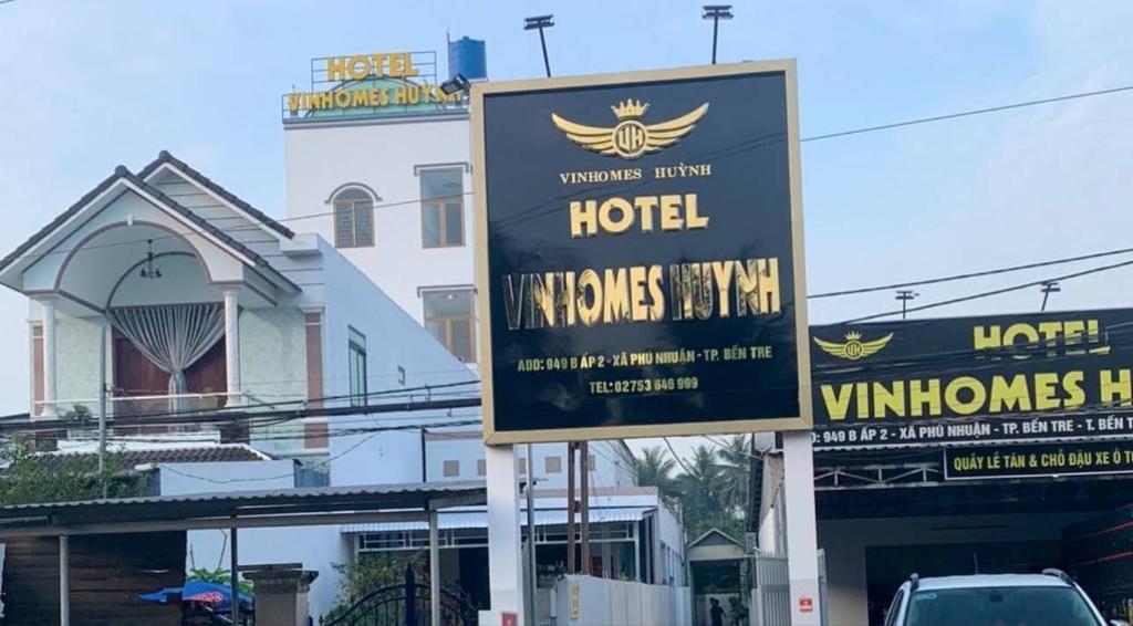 a sign for a hotel in front of a building at Khách Sạn Vinhomes Huỳnh in Phú Nhuận