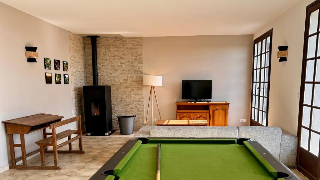 a living room with a pool table and a tv at Maison de Campagne in Chasnay