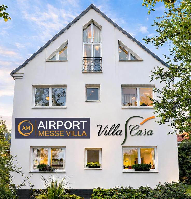a white building with a sign in front of it at Airport Messe Villa Casa in Düsseldorf