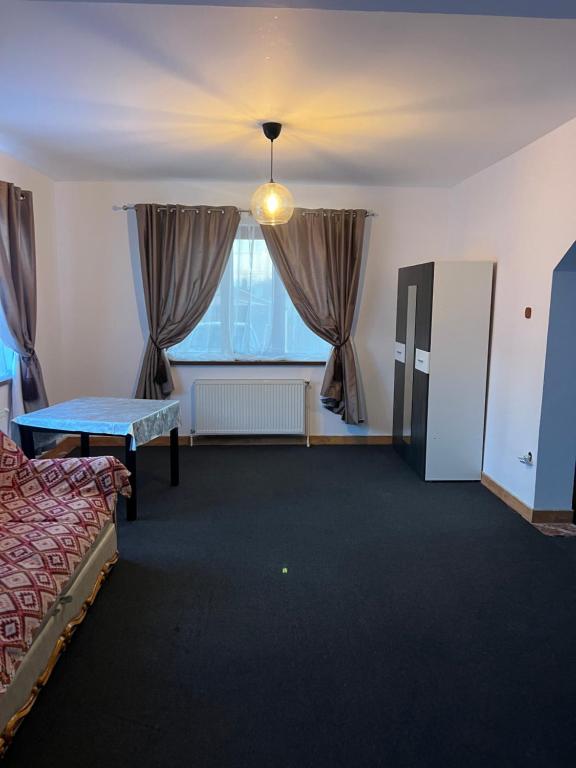 a room with a bed and a table and a window at Vila Maria in Roman