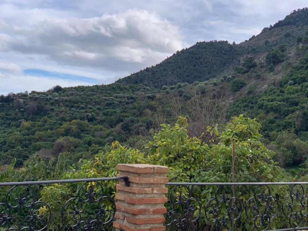 a brick chimney in front of a mountain at Hostel Los Guajares in Guájar-Faragüit