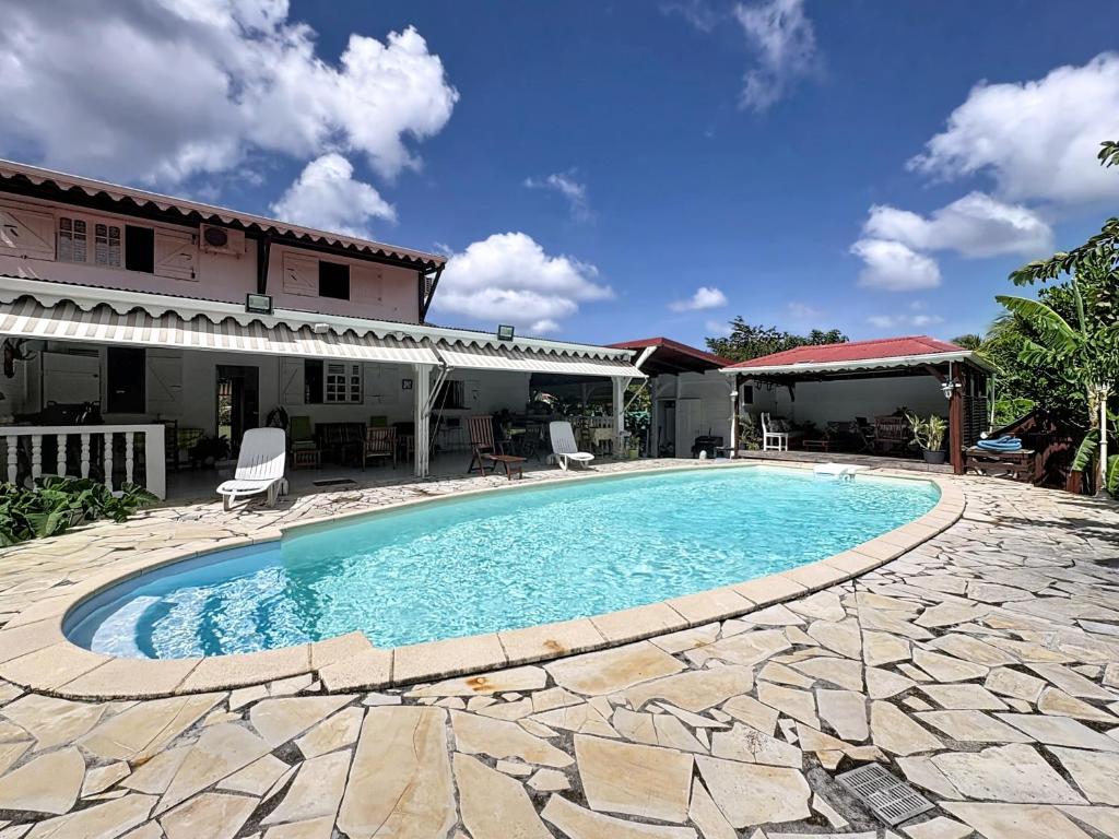 a swimming pool in front of a house at Villa Soleïa in Gourbeyre
