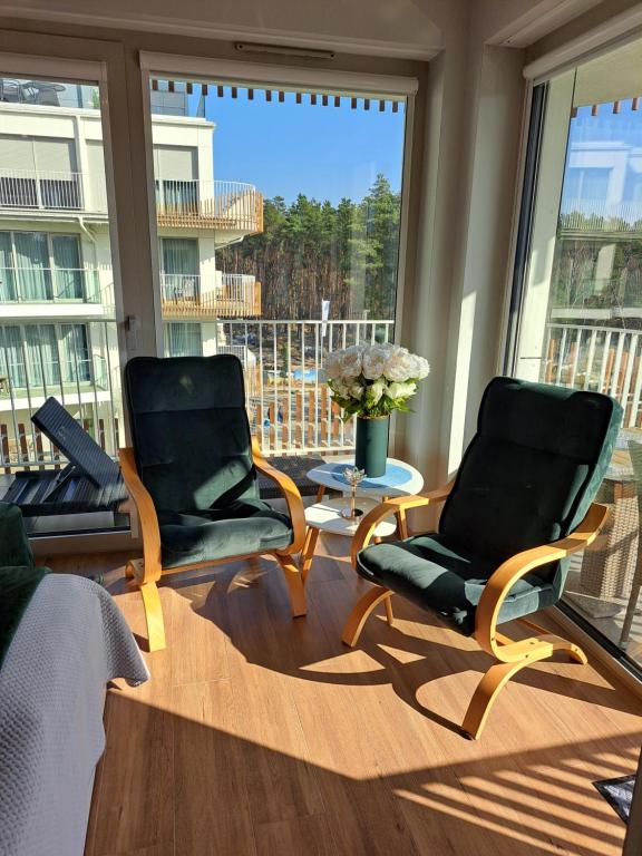 two chairs in a living room with a large window at Apartament RUBUS 305 Sofii in Świnoujście