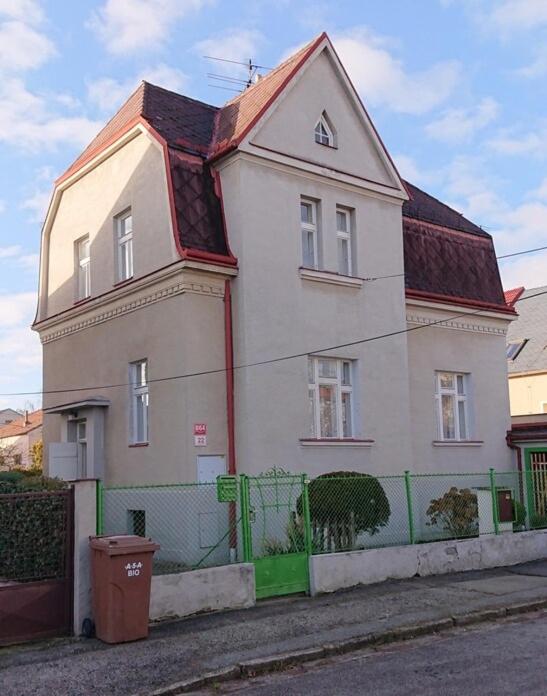 a white house with a green fence in front of it at Vila Jitka in České Budějovice