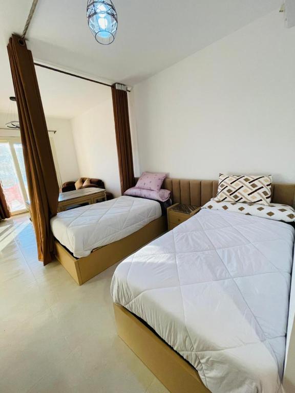 a bedroom with two beds and a mirror at vip ghazala in Dahab