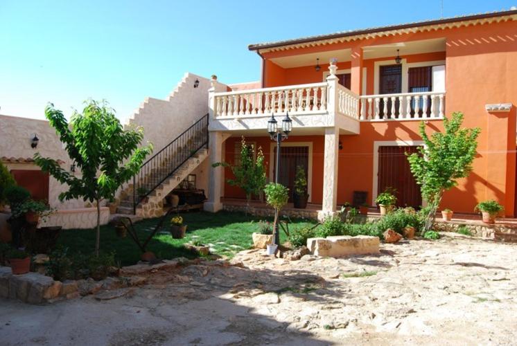 a large orange house with a balcony and stairs at Casanavalon in El Peral