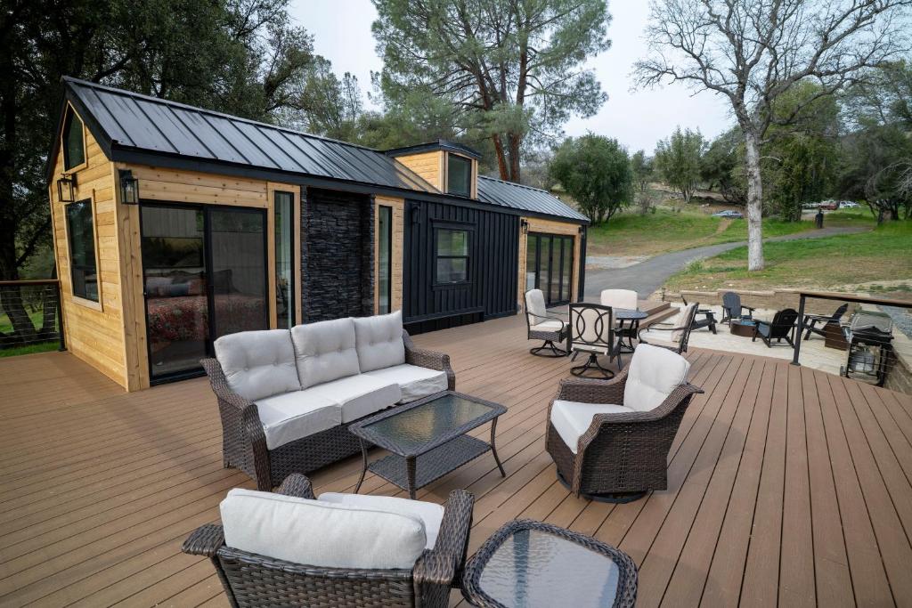 a screened in deck with chairs and a house at River Falls Retreat in Oakhurst