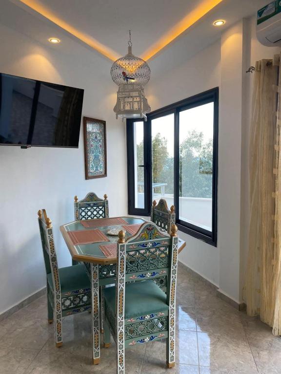 a dining room with a table and chairs and a chandelier at L Andalousie in Tabarka