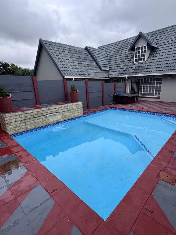a large swimming pool in front of a house at Countryview Chalet in Benoni