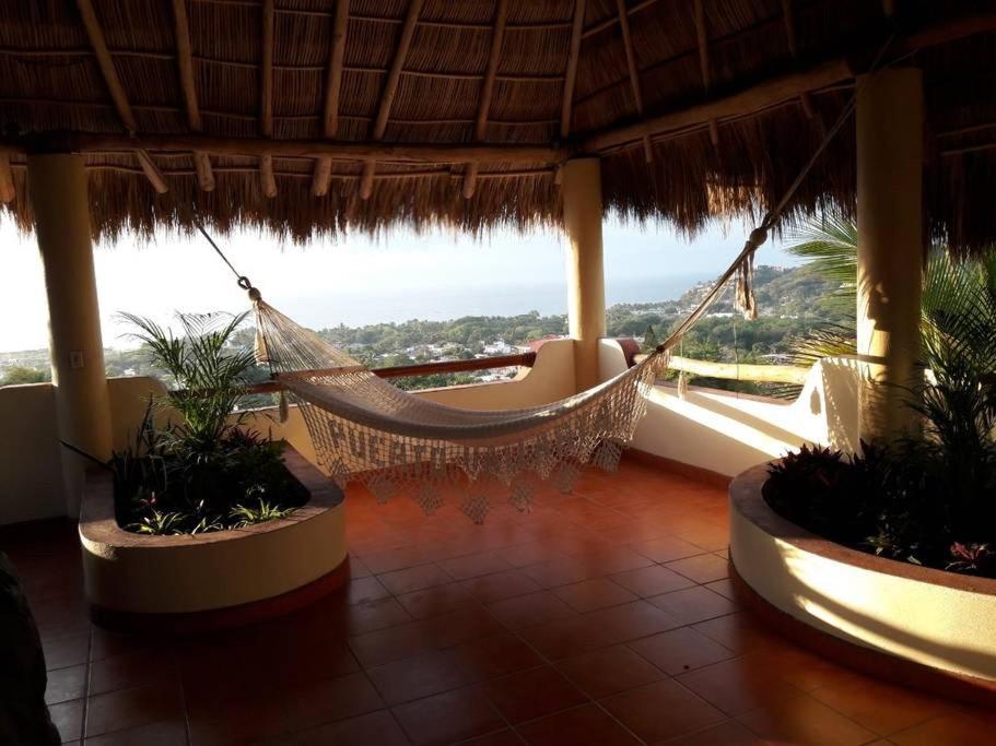 a hammock in a resort with a view of the ocean at Beautiful Tropical House with Ocean VIEWS! in Cruz de Huanacaxtle