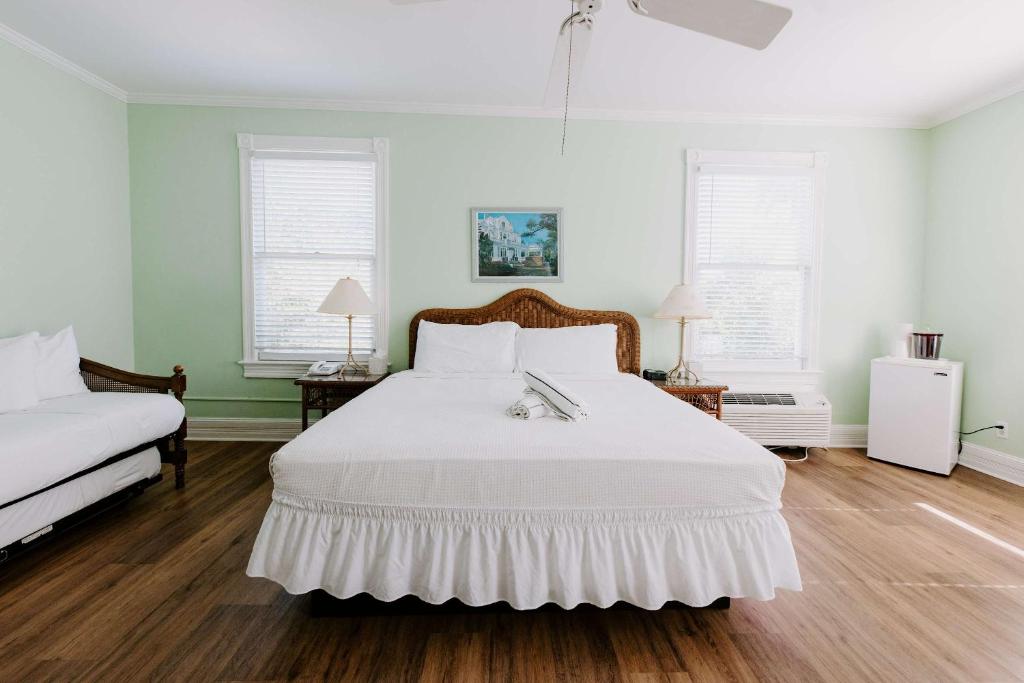 a bedroom with a white bed and two windows at Curry Mansion Inn in Key West