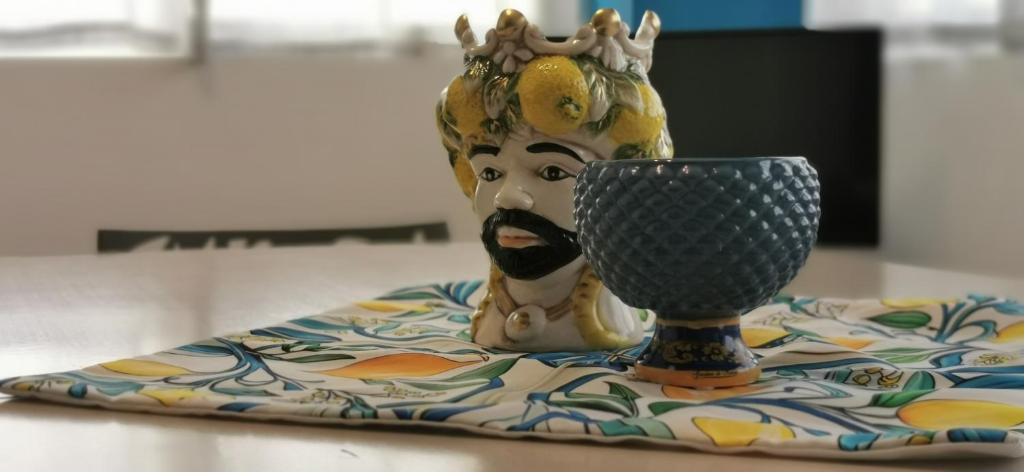 a statue with a crown and a cup on a table at Casa Vacanze Samelia in Altavilla Milicia