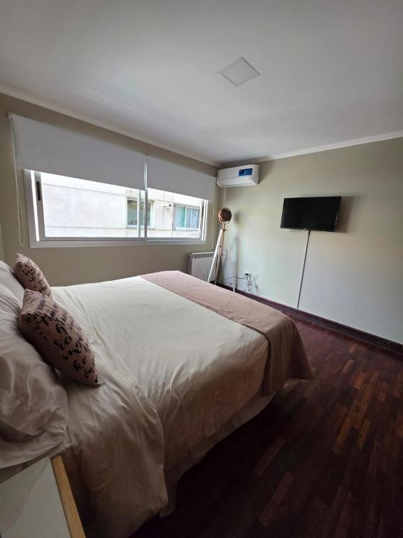 a bedroom with a large bed and a television at Departamento Casco Historico in La Porteña