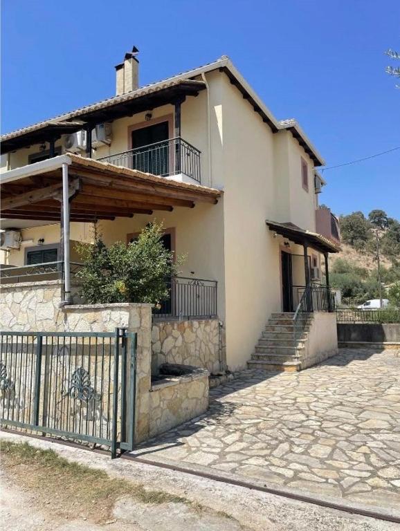 a house with a fence in front of it at Ioannis Apartment in Syvota