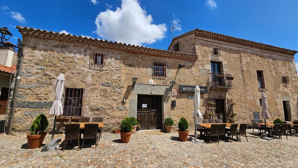 a building with tables and chairs in front of it at La Clerecia de Ledesma in Ledesma