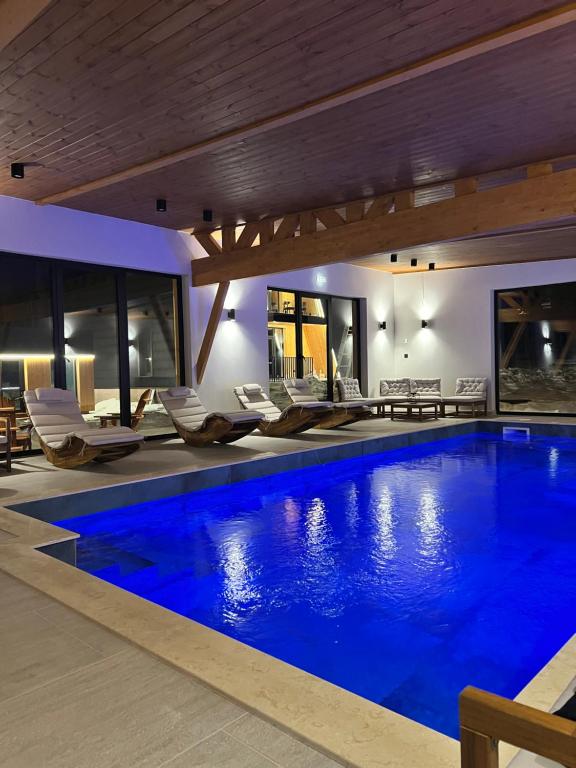 a large swimming pool with chairs in a house at ArcChalet Transylvania in Borzont