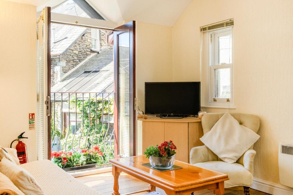 a living room with a tv and a table and a couch at The Retreat with Free Parking in Ambleside