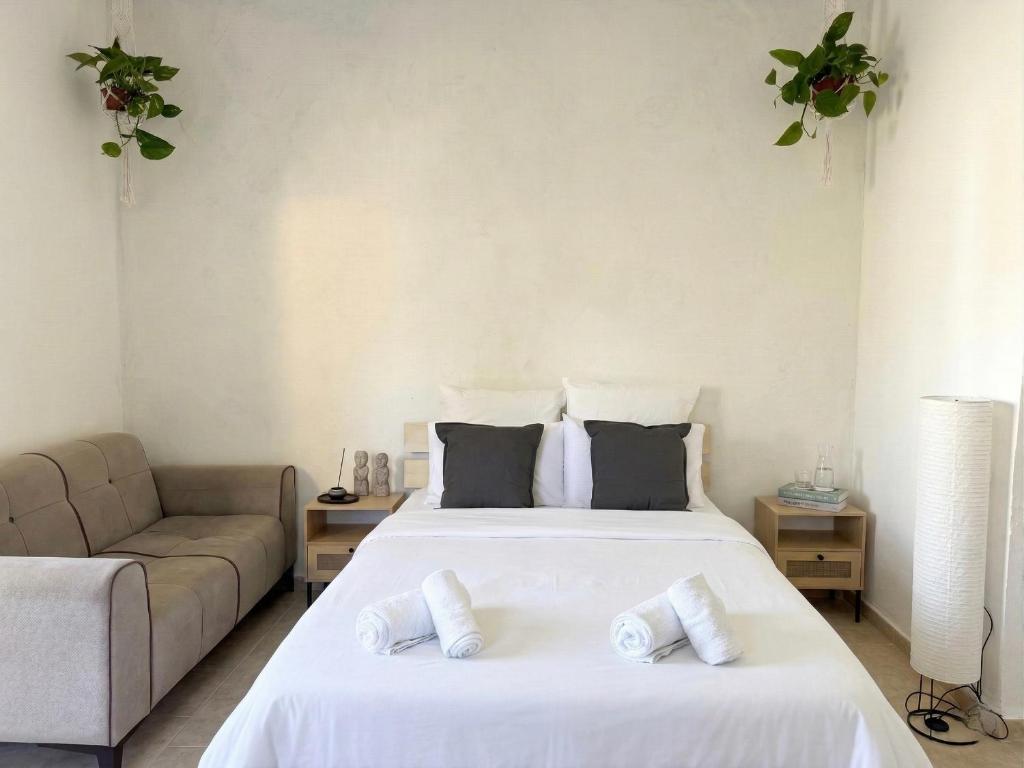 a bedroom with two beds and a couch at White Emerald in Haifa