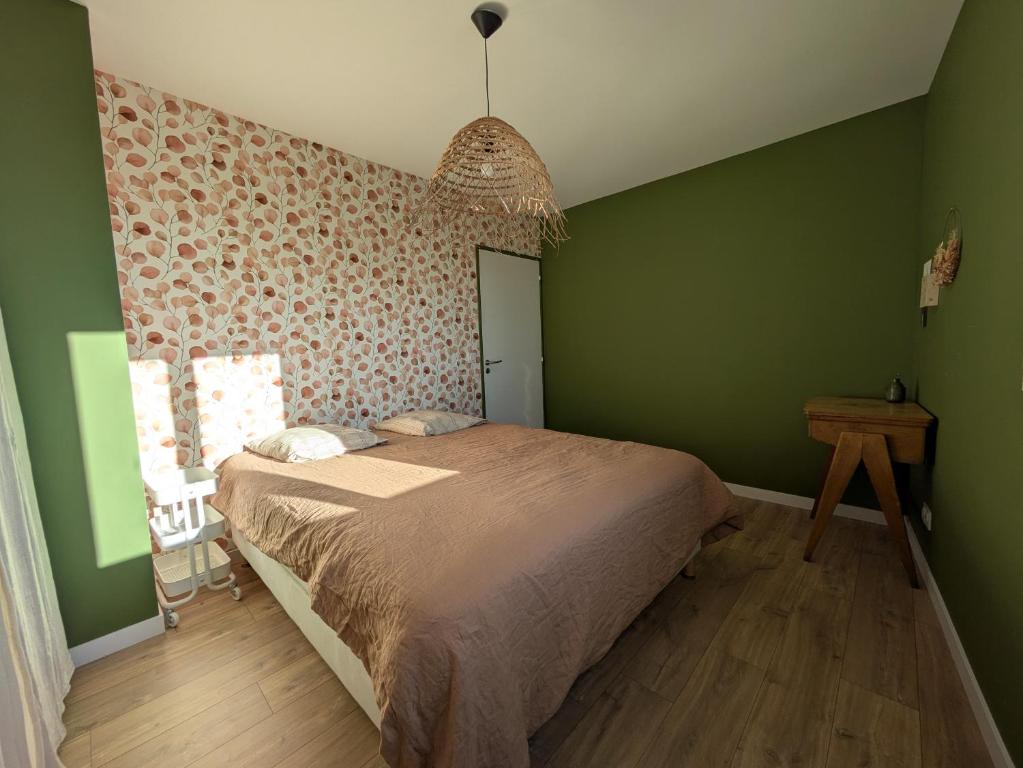 a bedroom with green walls and a large bed at Maison Terracotta in Saint-Priest-en-Jarez