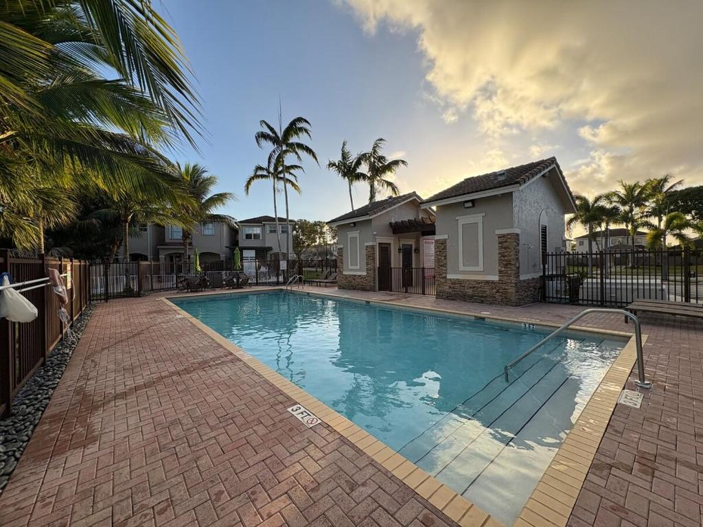 a large swimming pool in front of some houses at Miami Stay - Pool, Parking, & Affordable Transportation in Tamiami