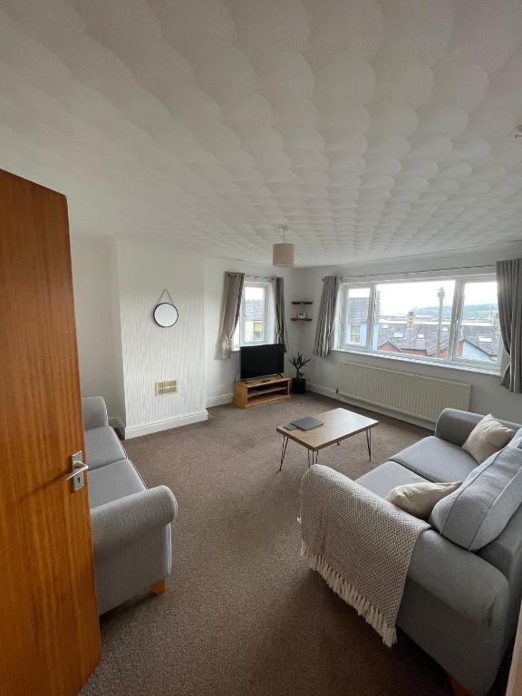a living room with a couch and a table at Penrhyn View in Bangor
