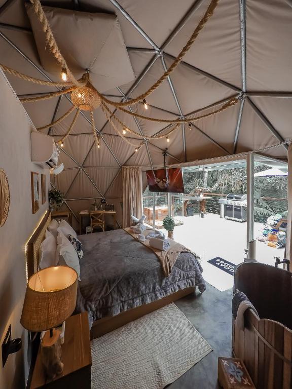 a bedroom with a large bed in a tent at Goat Lodge DOMO BALI in Ibiúna