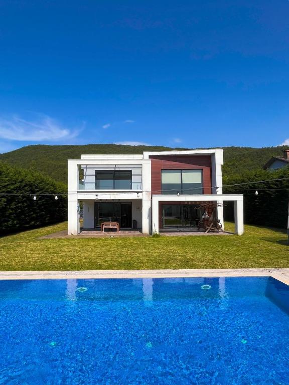 a house with a swimming pool in front of a house at Villa Meg with Private Pool, Sauna Jacuzzi in Kadıköy