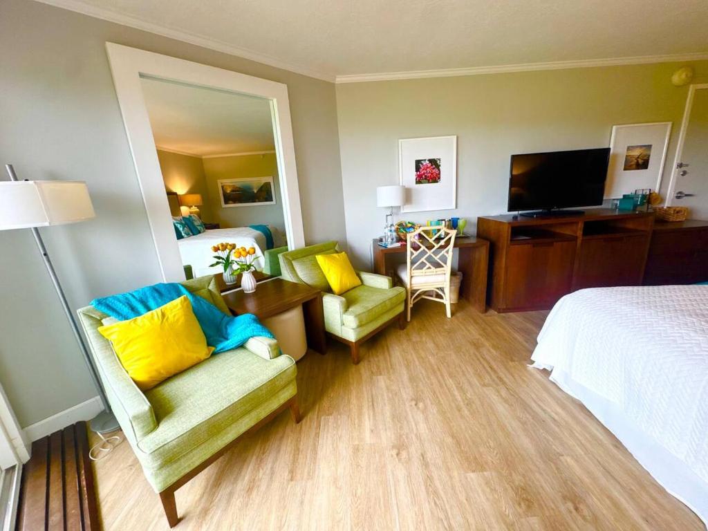 a hotel room with a bed and a couch and a chair at Pristine Hotel Room at Popular Resort in Lihue