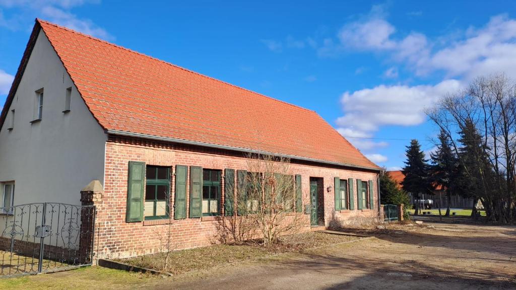 an old brick building with an orange roof at Alte Schule Rietz in Treuenbrietzen