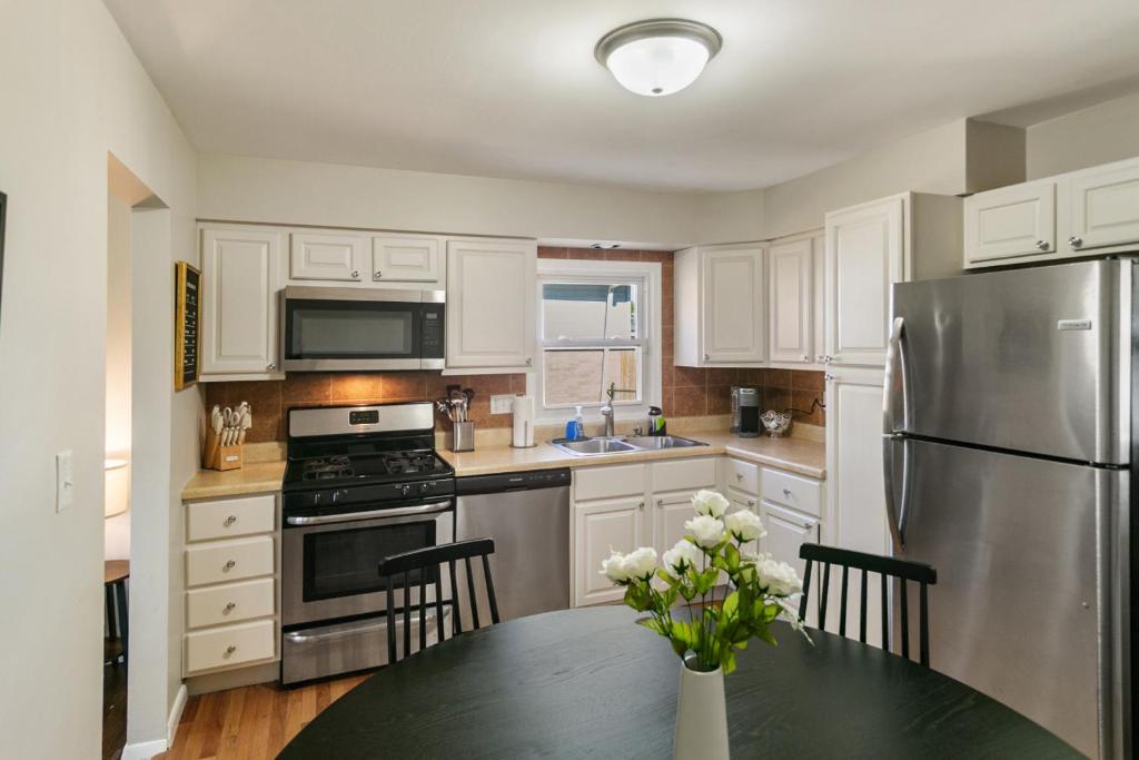 a kitchen with white cabinets and a table with a refrigerator at USS Anderson in Waukegan