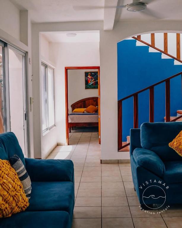 a living room with a blue couch and a bedroom at VISTAMAR Casa a pie de Playa in Playa Agua Blanca