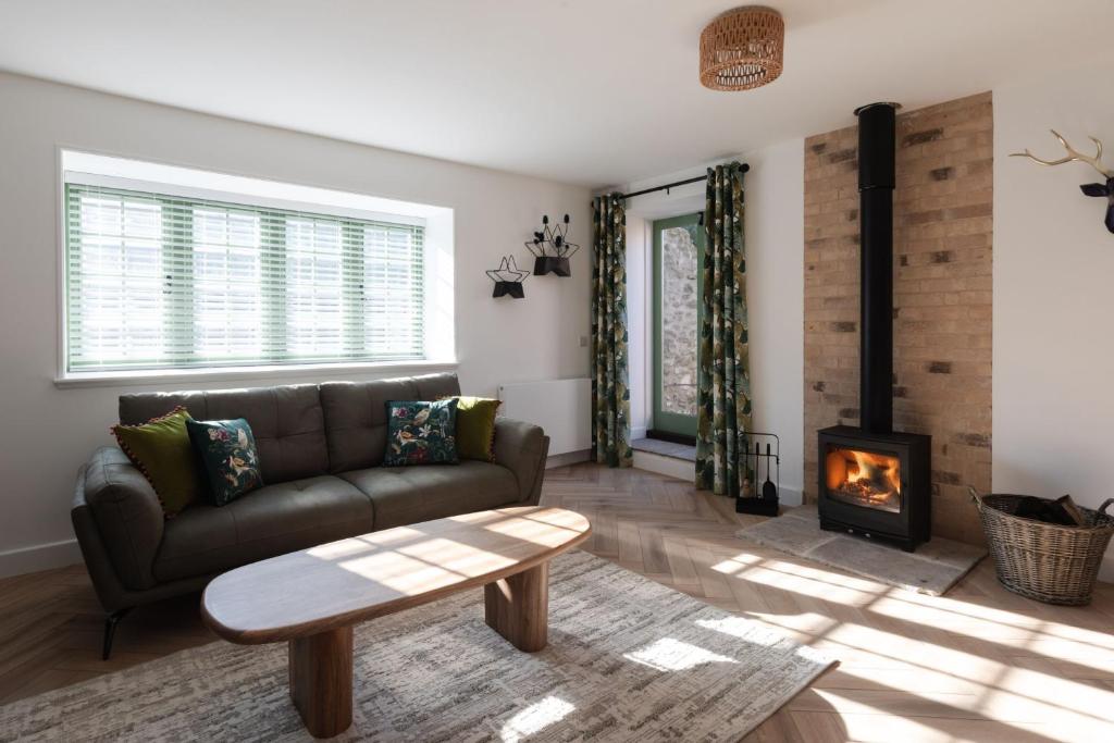 a living room with a couch and a fireplace at Sunray Cottage in Weymouth