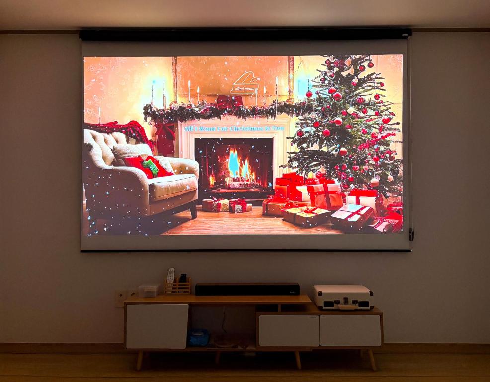 a tv screen with a christmas tree in a living room at 온담펜션 in Sŏnjae-do