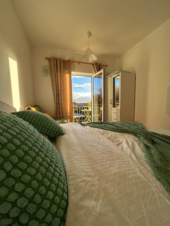 a bedroom with a bed and a large window at Europe's last sunset in Waterville