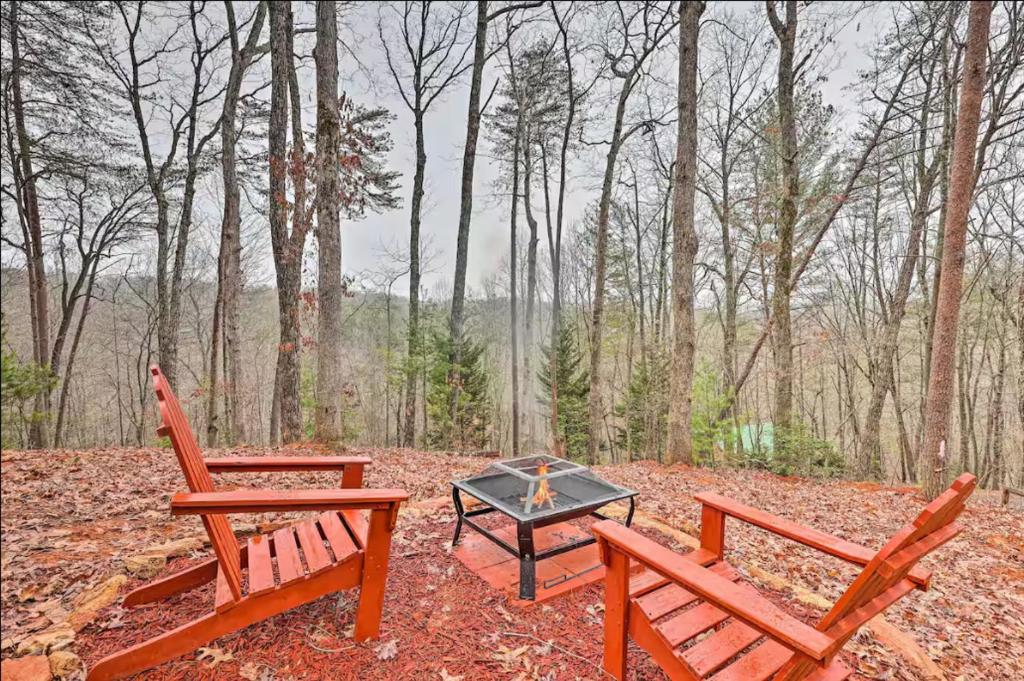 two wooden benches and a table in the woods at Sunrise Hideaway on Cherry Log Mountain in Blue Ridge
