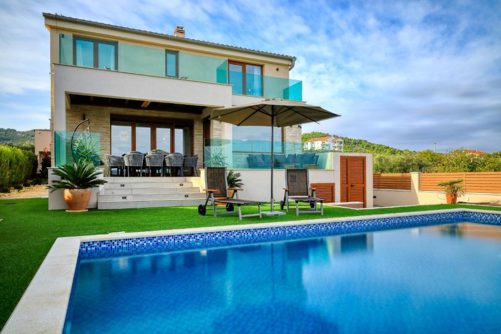 a house with a swimming pool in front of a house at Masanda in Ždrelac