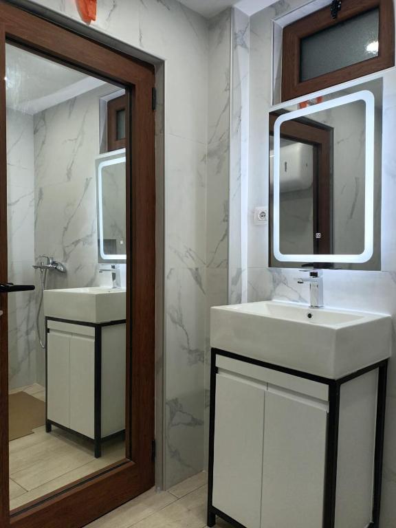 a bathroom with two sinks and a mirror at Guest House Mene in Gjirokastër