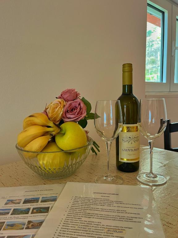 a bottle of wine and two wine glasses on a table at Apartments Lazarević in Kotor