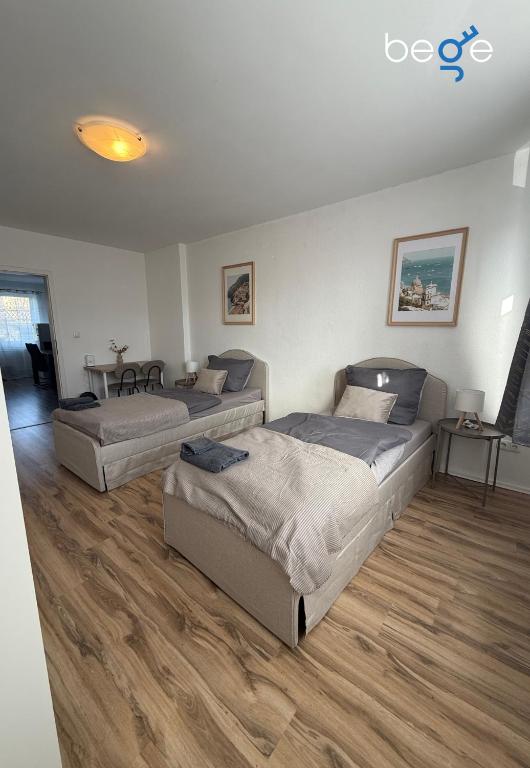 a bedroom with three beds and a table at BEGE APARTMENTS SmartLoft in Hof