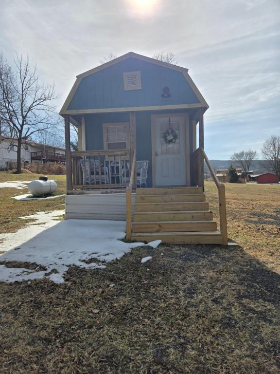 a small blue house with a porch and stairs at The Blue Goose in Marshall