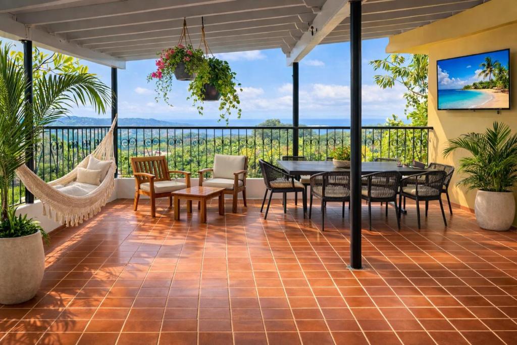a patio with a table and chairs and a hammock at crown y key in Ciales