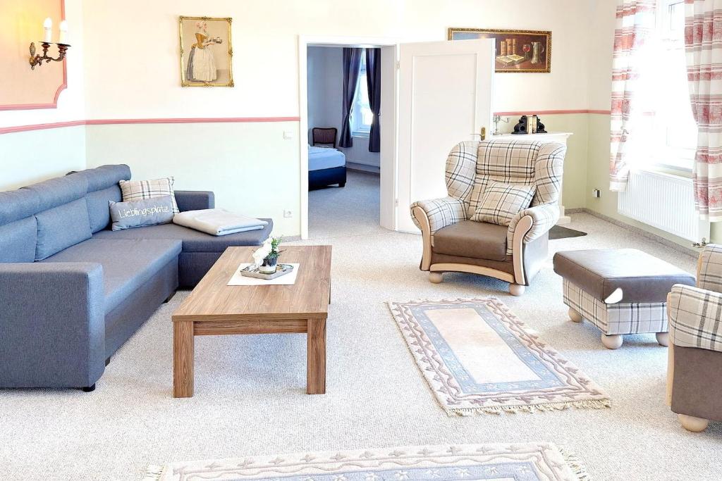 a living room with a blue couch and a coffee table at Zach Family in Lübbenau