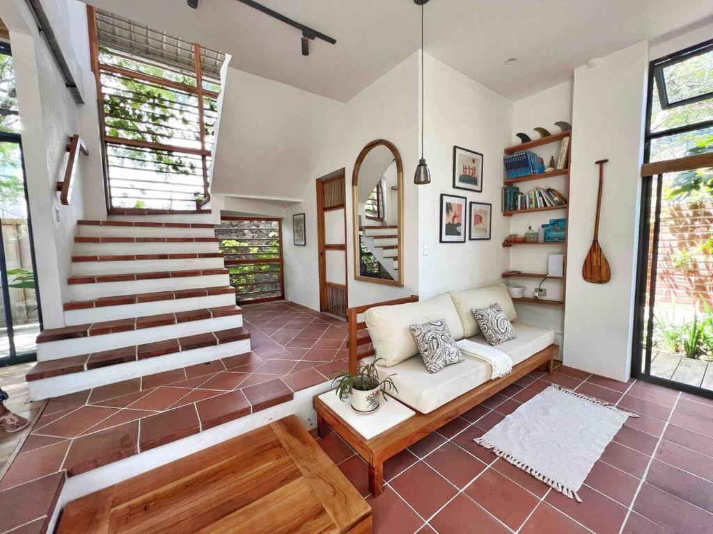 a living room with a couch and a staircase at Casa Isla - Private Retreat in Galapagos in Puerto Baquerizo Moreno