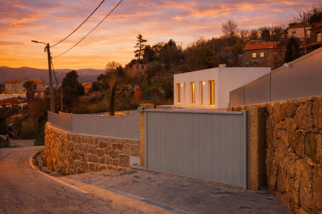 a building with a gate on the side of a road at Douro Garden in Resende