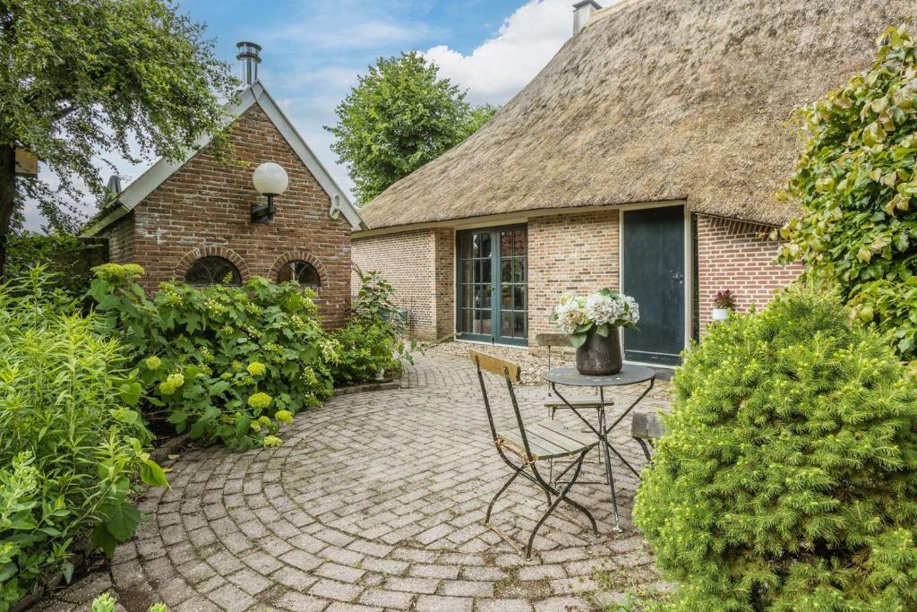 a brick house with a table and chairs in front of it at Hoeve 1650 in Koekange