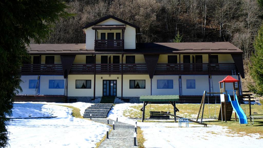 a house with a playground in the snow at NAD Inn in Sătic