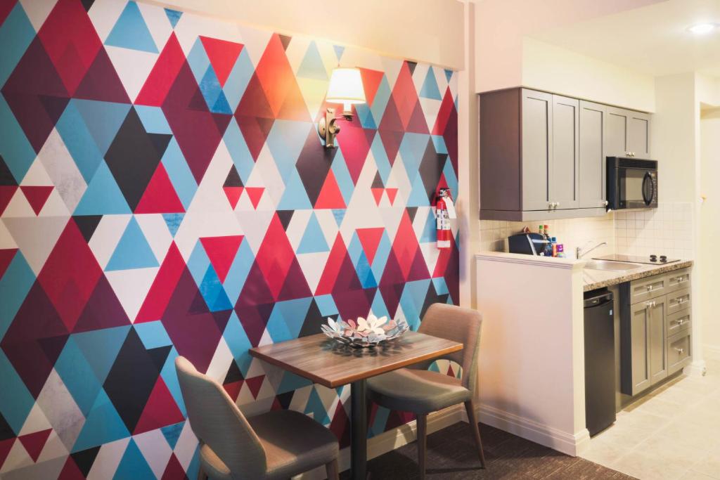 a kitchen with a table and a geometric wall at Summit Lodge Boutique Hotel by Paradox in Whistler