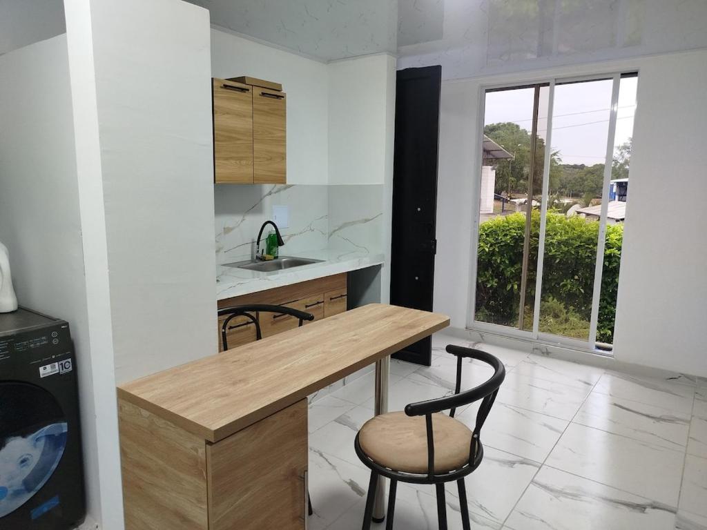 a kitchen with a wooden table and two chairs at Santa Marta 1 in Yopal