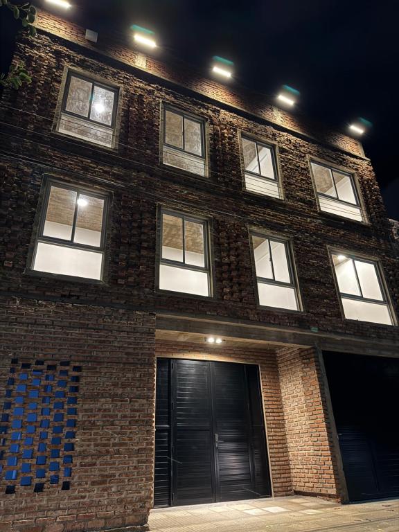 ein Backsteingebäude mit vielen Fenstern in der Unterkunft Urban River Hostel in Corrientes